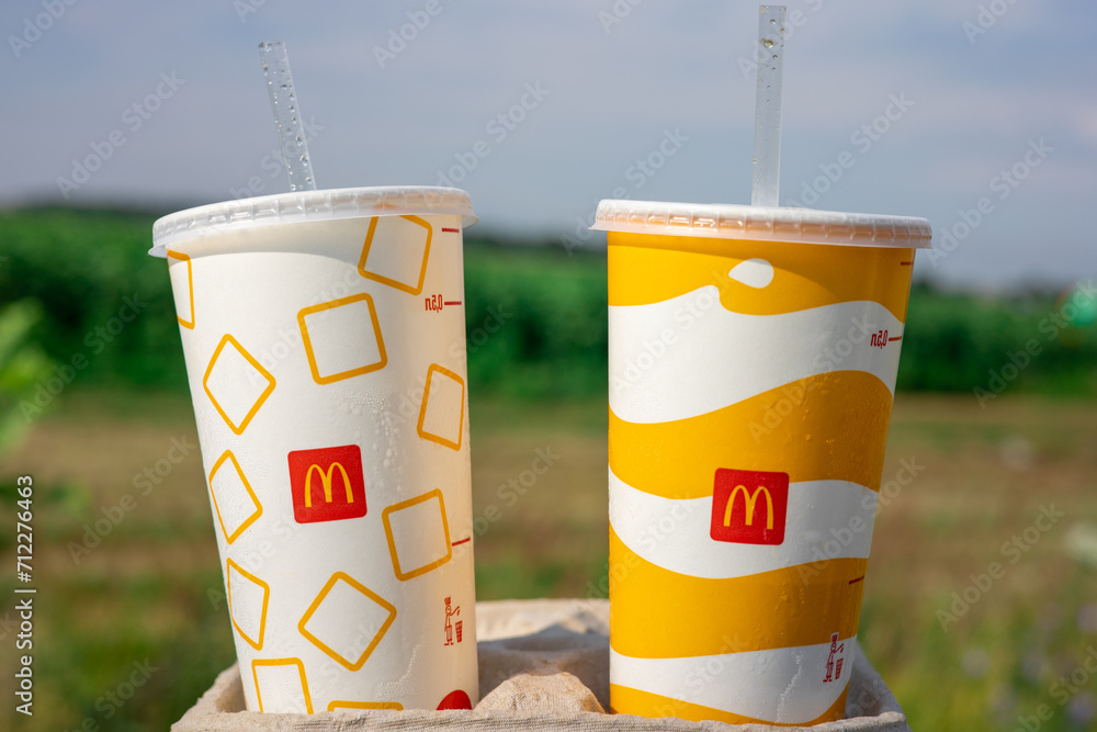 Two paper cups of soda water. Large McDonald's cup with soft drink. The ...
