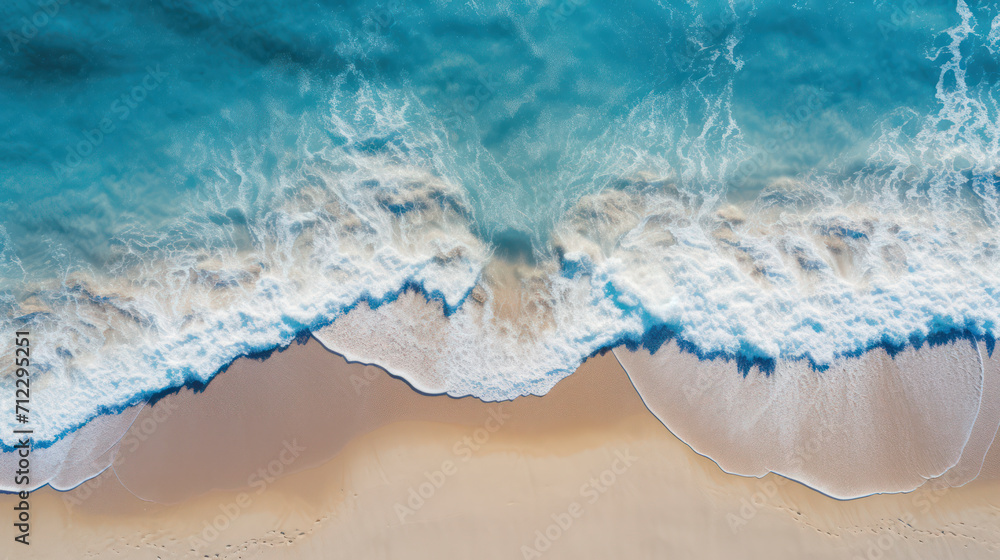 Fototapeta premium Top down view of tropical beach waves engulfing the sand