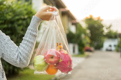 Woman hands carry in a plastic bag fruits on the way home. Hands holding plastic bags for shopping. Set zero waste plastic free concept. Sustainable lifestyle concept.