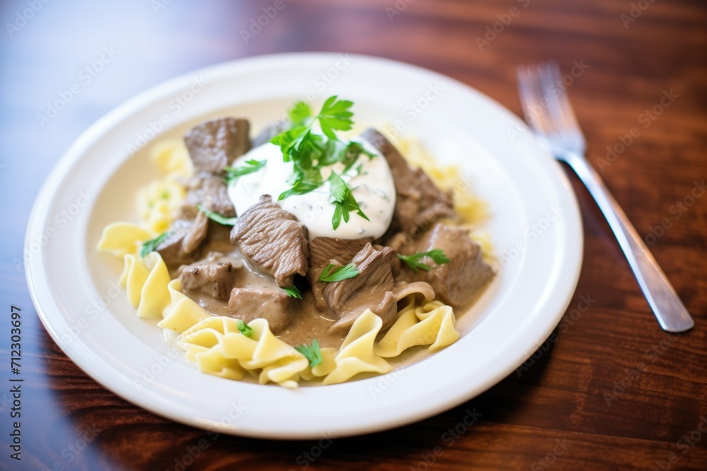 beef stroganoff served over egg noodles with a dollop of sour cream