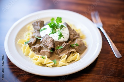 beef stroganoff served over egg noodles with a dollop of sour cream