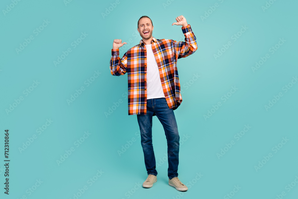 Full length photo of perky self confident man wear flannel shirt jeans pants directing at himself isolated on turquoise color background Full length photo of perky self confident man wear flannel shirt jeans pants directing at himself isolated on turquoise color background