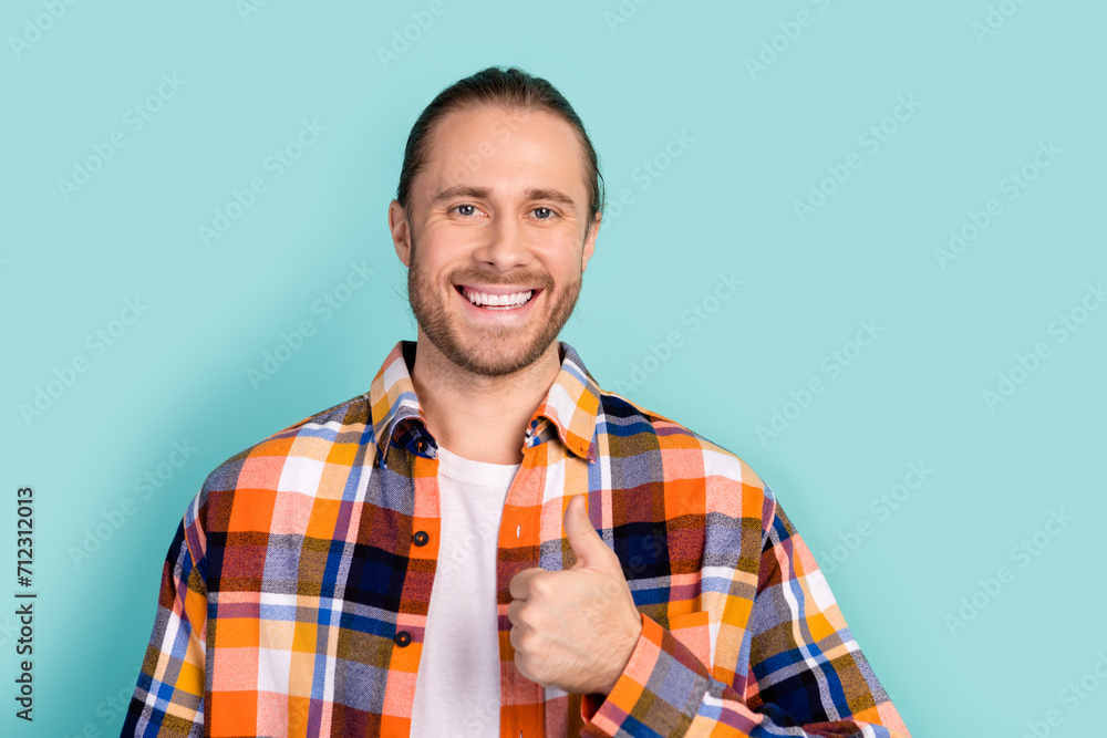 Portrait of toothy beaming positive man with stubble wear flannel plaid jacket showing thumb up isolated on turquoise color background Portrait of toothy beaming positive man with stubble wear flannel plaid jacket showing thumb up isolated on turquoise color background