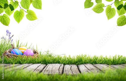 Obraz na płótnie A blank template of three painted easter eggs in a birds nest celebrating a Happy Easter with a wooden bench to place products on with green grass and tree leaves on a transparent background w salonie