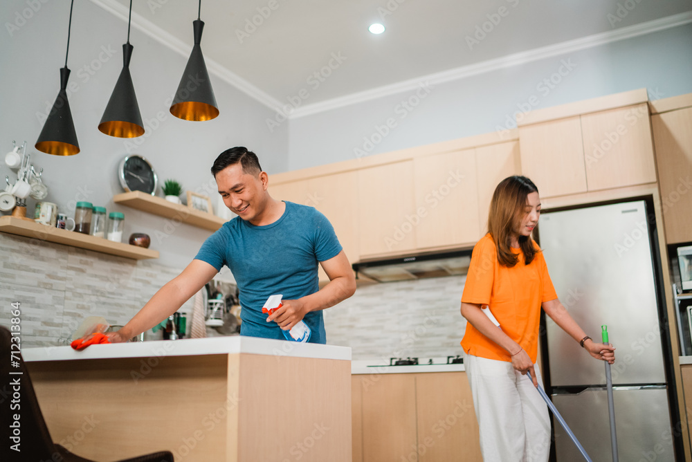 low angle view asian couple cleaning their kitchen together low angle view asian couple cleaning their kitchen together