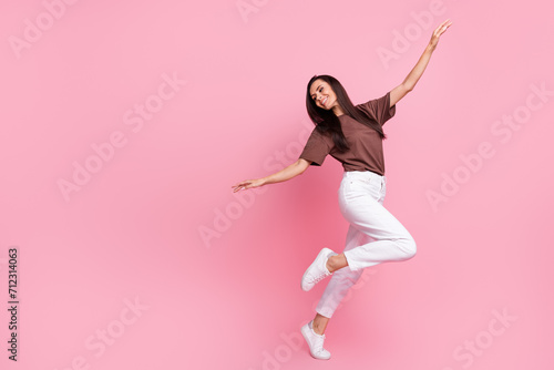 Full body profile photo of pretty positive lady raise hands good mood dance empty space isolated on pink color background