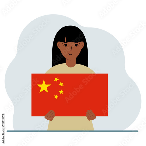 A woman holds a Chinese flag. The concept of demonstration, national holiday or patriotism. Nationality.