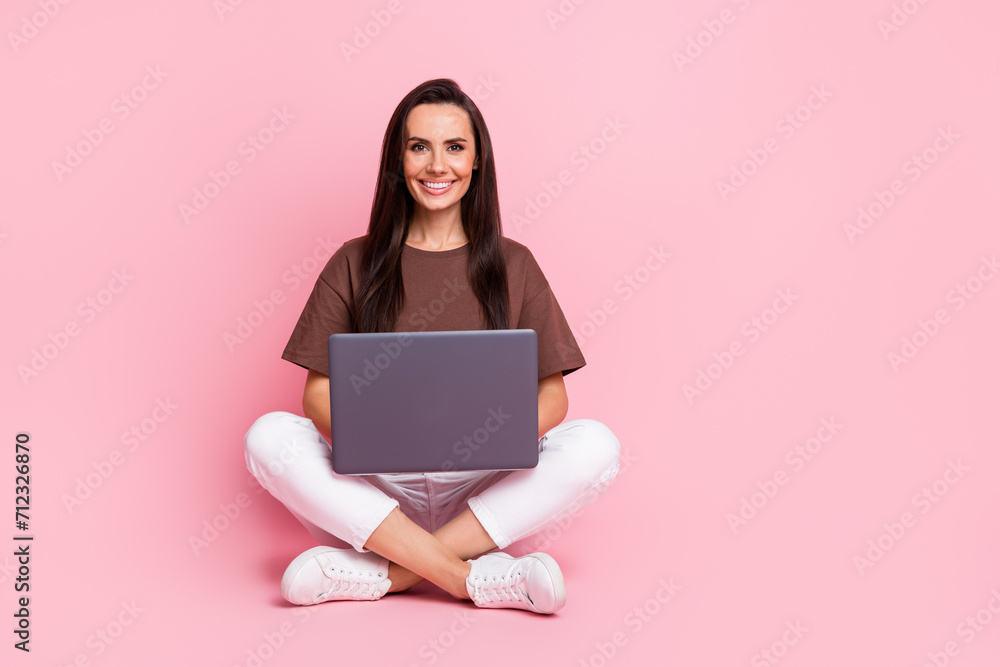Full body photo of it courses advertisement young teacher in programming academy sitting with netbook isolated on pink color background Full body photo of it courses advertisement young teacher in programming academy sitting with netbook isolated on pink color background