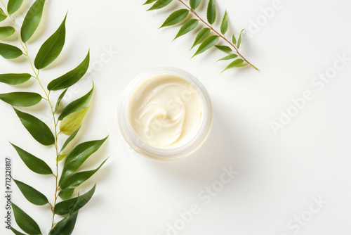 Still life of cosmetic jar with cream with leaves on white background, skin care concept, top view photo