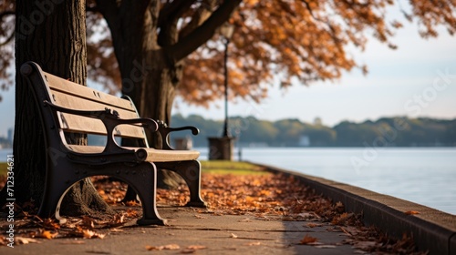 Bench in the park near the lake shore. The fall season, fallen leaves. Generative ai photo