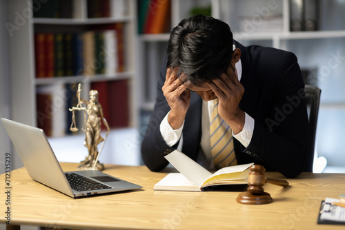 Male lawyer, legal advisor, sitting sad and solving problems in office Sitting at the table with my face covered. Customer Crisis Negotiation Concept