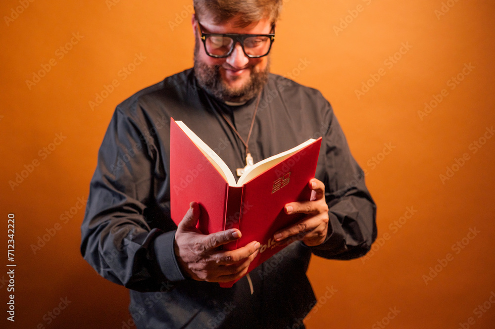 Portrait of a priest with crucifix and black shirt holding a bible. Portrait of a priest with crucifix and black shirt holding a bible.