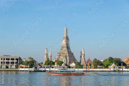 Beautiful temple of dawn Wat Arun Ratchawararam buddhist temple famous with boat and blue sky sunny day travelin Bangkok, Thailand. © Chalearmrat