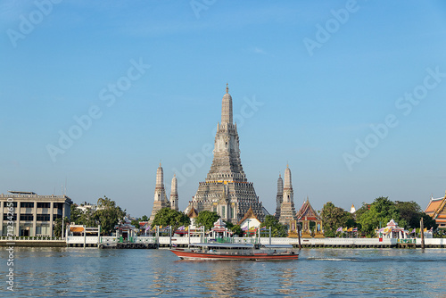 Beautiful temple of dawn Wat Arun Ratchawararam buddhist temple famous with boat and blue sky sunny day travelin Bangkok, Thailand.