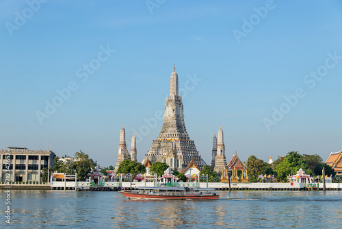 Beautiful temple of dawn Wat Arun Ratchawararam buddhist temple famous with boat and blue sky sunny day travelin Bangkok, Thailand.