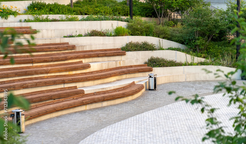 Obraz na płótnie Curved concrete steps with wooden slats and flowers in the amphitheater in the c