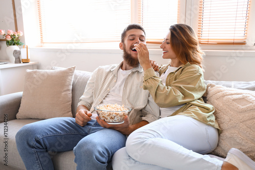 Happy couple in love eating popcorn at home photo