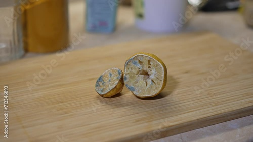 Moldy lemon on wooden cutting board. photo