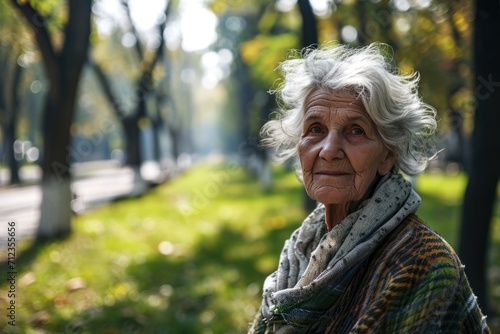 Portrait of an elderly gray-haired woman in the park during the day