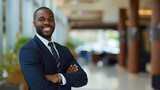 a black male business man smiling and standing confidently in an office building