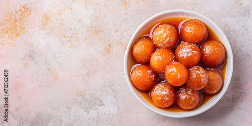 Top view Succulent Gulab Jamun Dessert. Juicy Gulab Jamun in syrup, sprinkled with sugar, on a pastel backdrop with copy space. photo