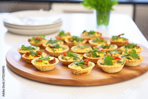 individual mini quiche lorraines on a platter with parsley