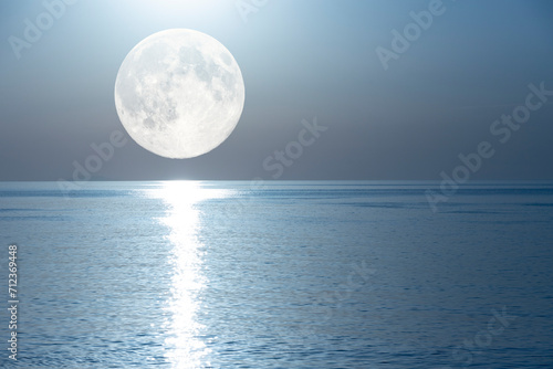 Full moon with a lunar path reflected in the mirror of the sea. © Iryna