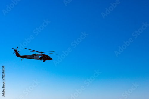 Fototapeta Naklejka Na Ścianę i Meble -  Military American helicopter flies in the blue sky. Military, rescue equipment.