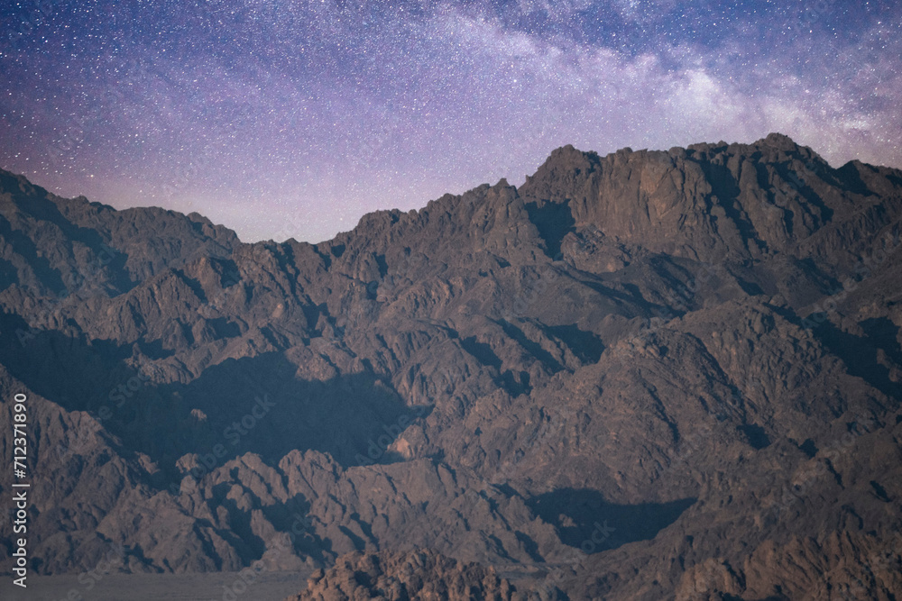Night landscape, mountain range, rocks, stone peaks against the background of the night sky with stars and the Milky Way, Sinai.