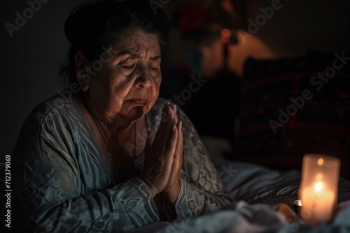 A woman praying at her bedside, prayer, faith, belief in god concept photo