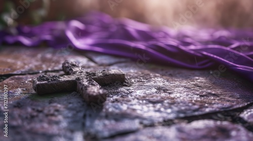 Ash Wednesday concept with a cross of ashes on a stone surface, purple cloth in the background, solemn and meditative mood, natural light. photo