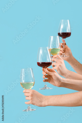 Women with glasses of wine on blue background. Valentine's Day celebration
