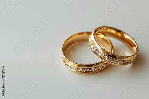 a gold rings with gems or diamonds on a white background, copy space for text, wedding or engagement couple rings, Valentine's Day,
