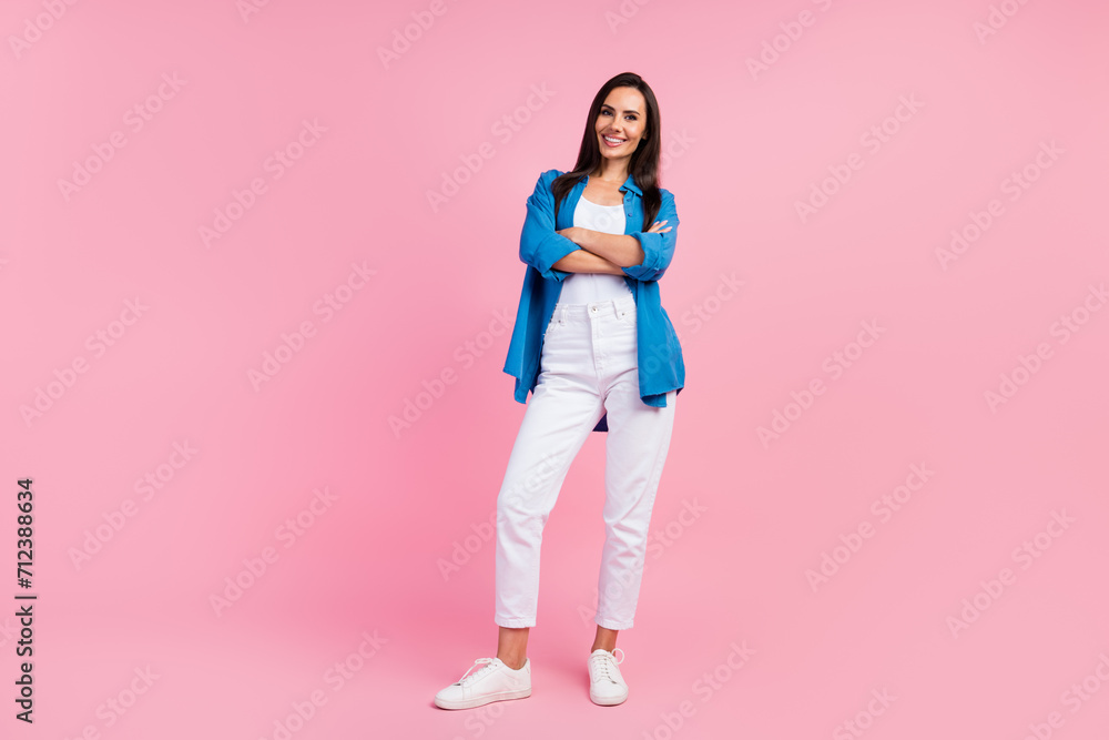 Full size photo of satisfied optimistic girl dressed blue shirt white trousers keep palms folded isolated on pink color background Full size photo of satisfied optimistic girl dressed blue shirt white trousers keep palms folded isolated on pink color background