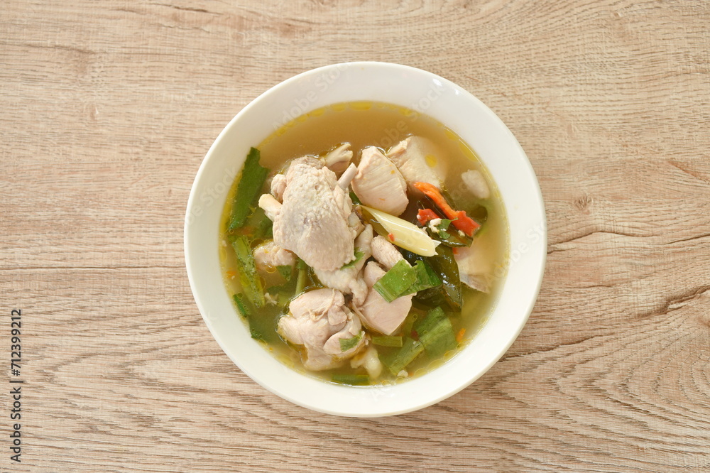 spicy boiled chicken and bone with herb leaf tom yum soup on bowl spicy boiled chicken and bone with herb leaf tom yum soup on bowl