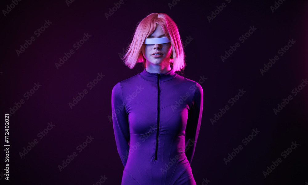 Woman in futuristic costume. Female in modern VR glasses interacting with network while having virtual reality experience. Augmented reality game, future technology, AI concept. VR. Woman in futuristic costume. Female in modern VR glasses interacting with network while having virtual reality experience. Augmented reality game, future technology, AI concept. VR.