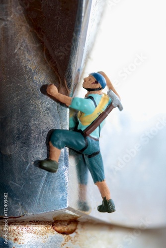 miniature figurine of a mountaineer climber climbing a wall