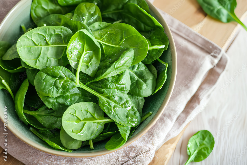 a bowl of spinach above wooden table a bowl of spinach above wooden table