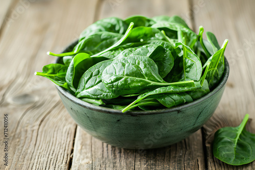a bowl of spinach above wooden table