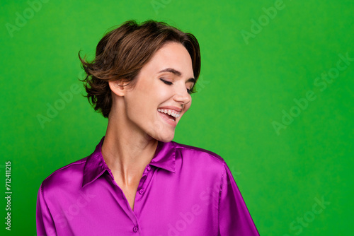 Portrait of gorgeous satisfied glad girl beaming smile empty space ad isolated on green color background