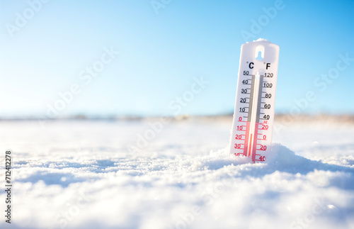 Thermometer in the winter snow showing sub zero minus temperature photo