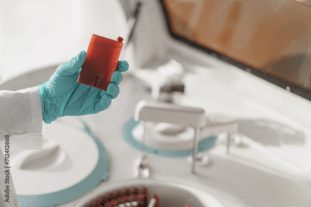 Close up of scientist's hand in gloves putting a small plastic test tube in a microcentrifuge Close up of scientist's hand in gloves putting a small plastic test tube in a microcentrifuge