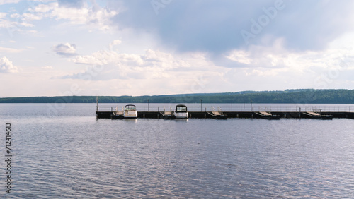 River motorboats are parked near the pier. River pier with boats. Relaxing on the water. © Eduard Belkin