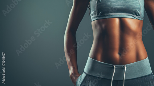 Generative AI, Sporty woman with great abdominal muscles shows stomach in sportswear on neutral background photo