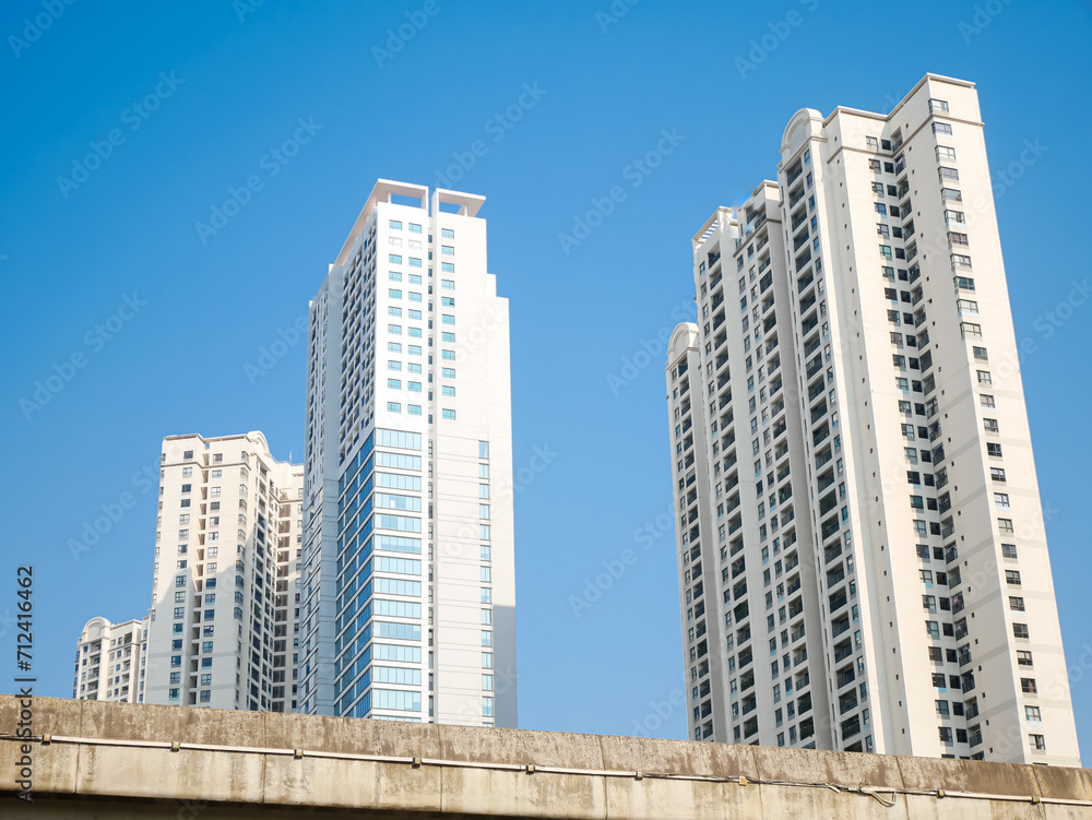 Elevated road highway looking up view of high-rise apartment complex condominium buildings, sunny clear blue sky near downtown Hanoi, Vietnam, upscale residence Asian real estate market Elevated road highway looking up view of high-rise apartment complex condominium buildings, sunny clear blue sky near downtown Hanoi, Vietnam, upscale residence Asian real estate market