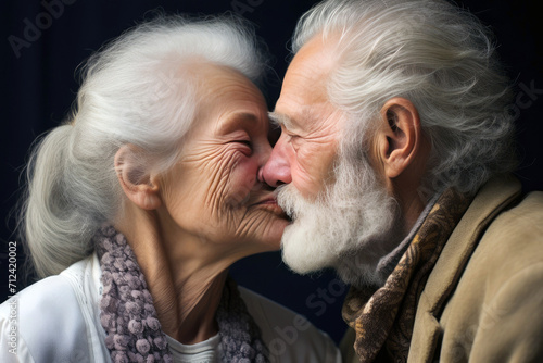 Close up portrait of a couple of pensioners kissing on a dark background