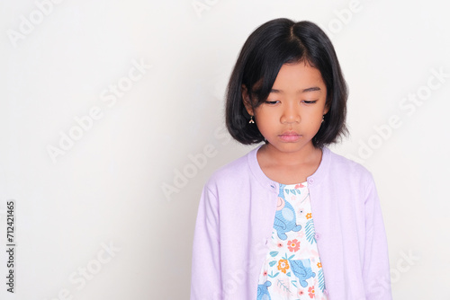 Asian kid bowed down listlessly and showing sad expression photo