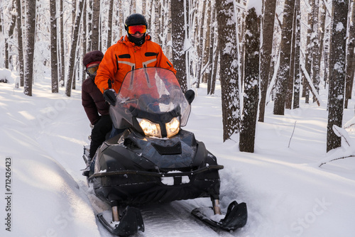 Athlete on a snowmobile moving in the winter forest in the mountains of the Southern Urals