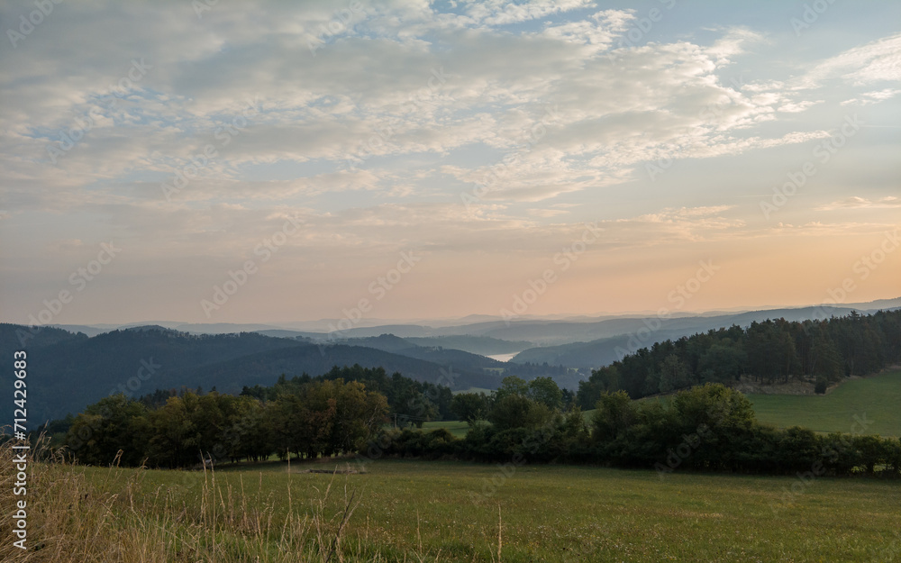 Obraz premium Wooded hilly landscape in the Czech Republic with Milada lookout tower above the Vltava River meander.