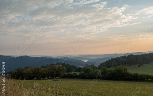 Wooded hilly landscape in the Czech Republic with Milada lookout tower above the Vltava River meander.